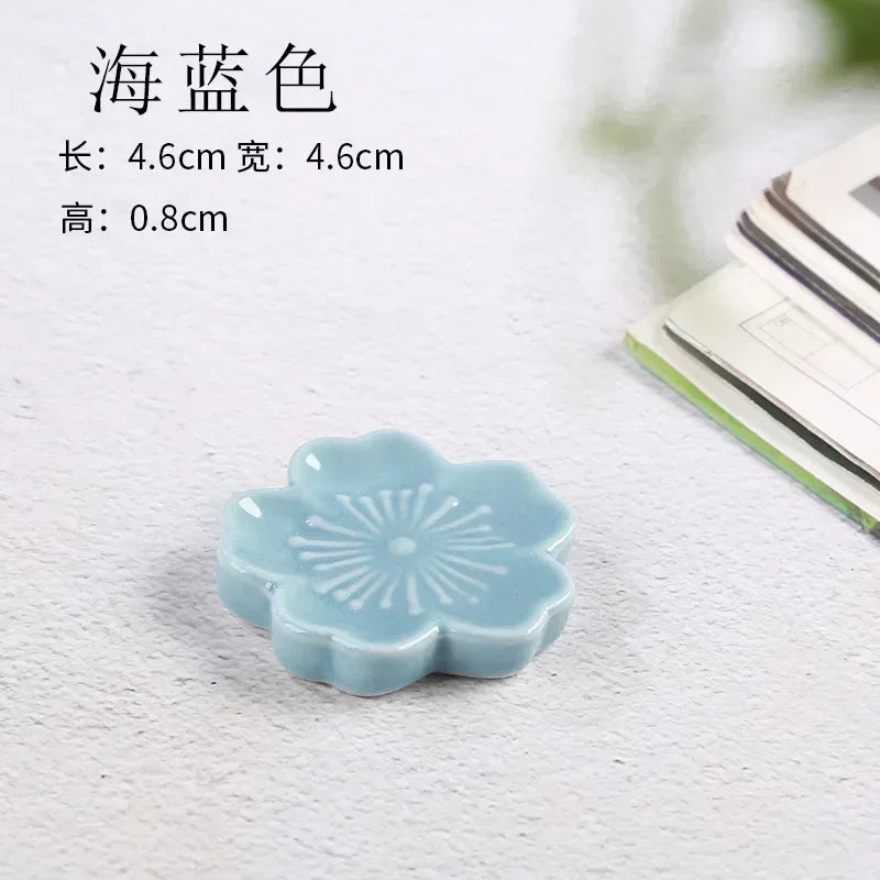 Light blue ceramic flower-shaped kawaii chopstick holder on a textured surface with text overlay.