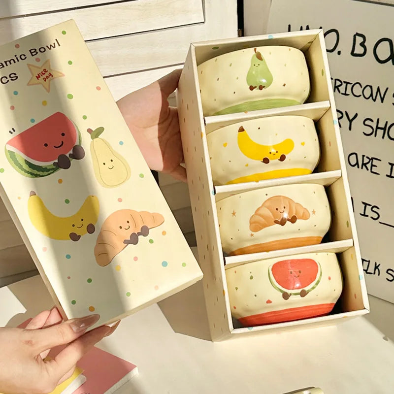 Four kawaii bowls with cartoons on them inside a container