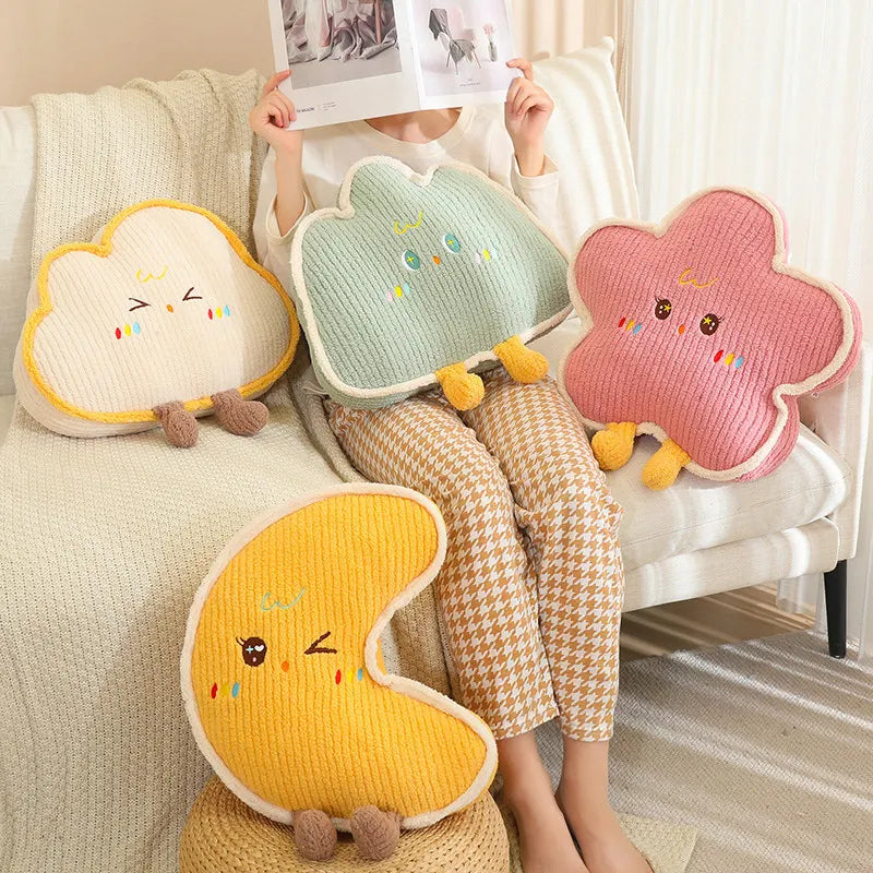 Person sitting on a bed with cloud-shaped kawaii cushions and a book, surrounded by plush toys.
