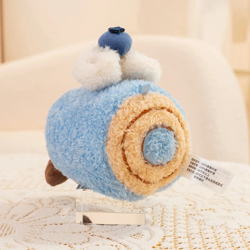Kawaii plush toy resembling a roll of toilet paper with a small figure on top, on a textured surface.