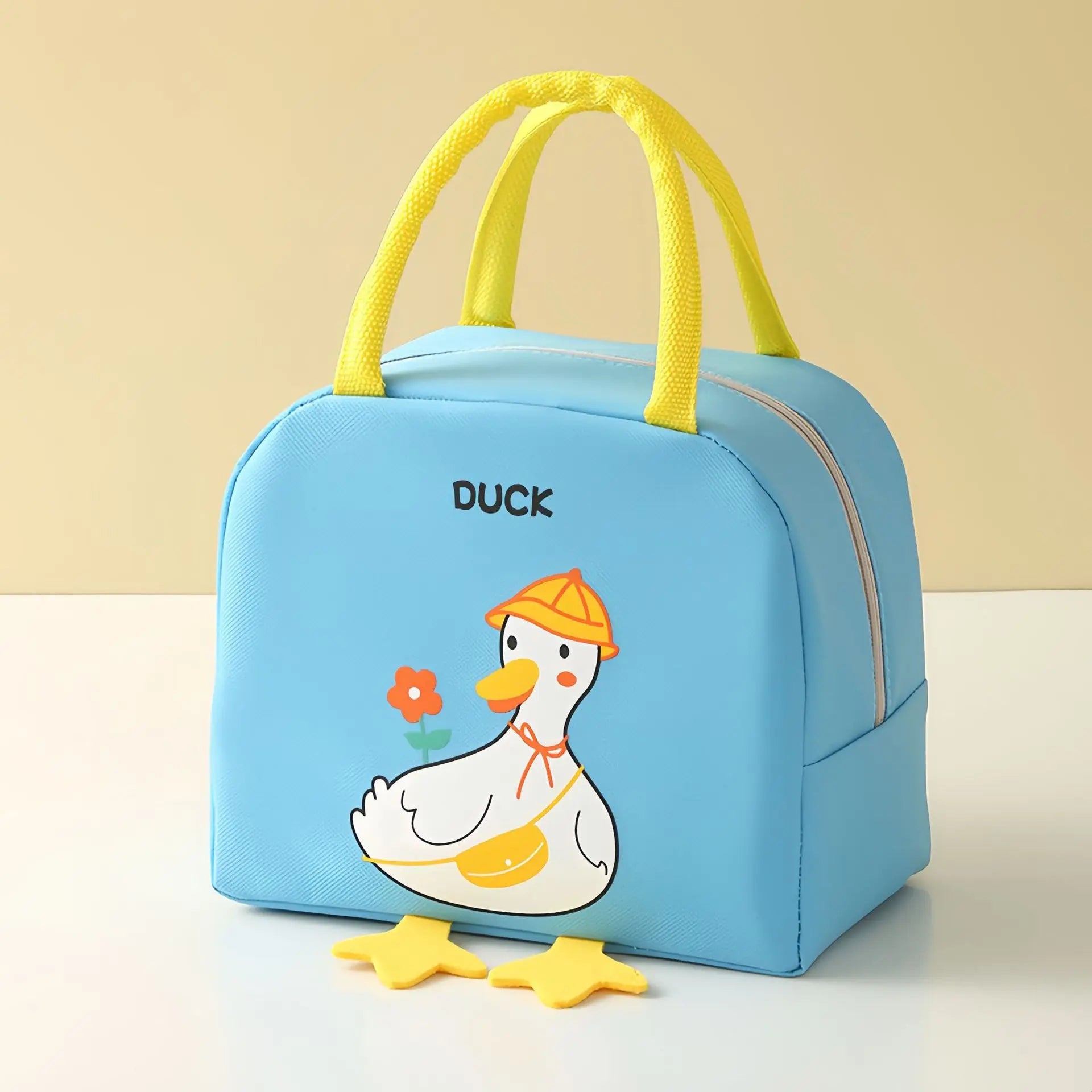 Blue kawaii lunch bag with cartoon duck design on a beige background