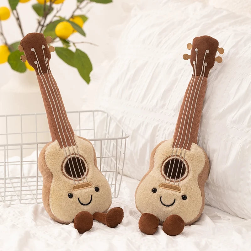 Two kawaii plush toy guitars with smiling faces on a white surface with a blurred background