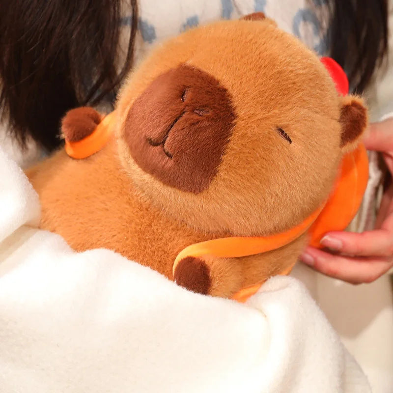 Close-up of a brown kawaii plush toy with a smiley face held by a person.