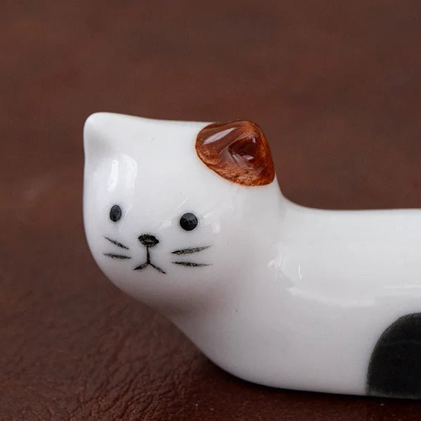 Ceramic cat kawaii chopstick holders with a brown ear on a brown background
