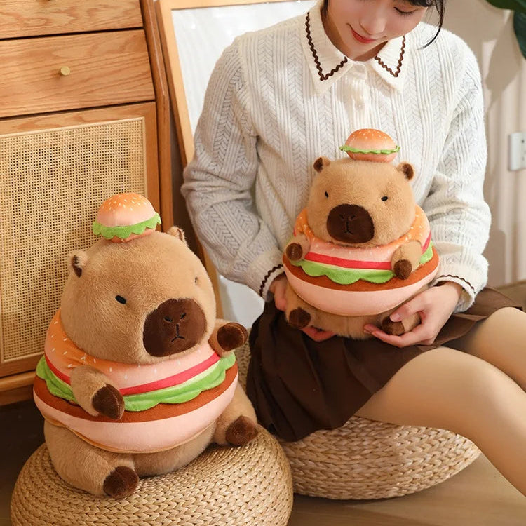 Person holding a kawaii plush toy shaped like a hamburger bear, sitting on a woven stool.