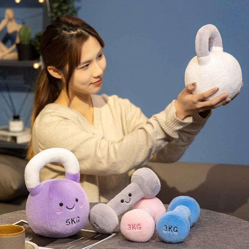 Woman holding a kawaii plush toy dumbbell with other similar toys on a table.