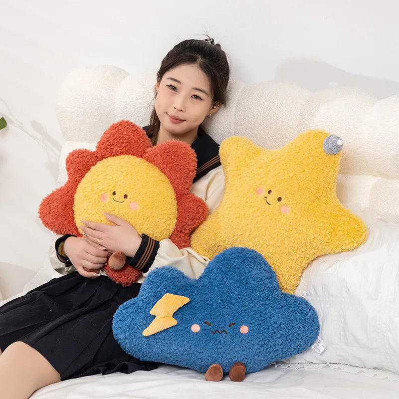 Person holding a sun-shaped kawaii plush toy with two other plush toys on a white background