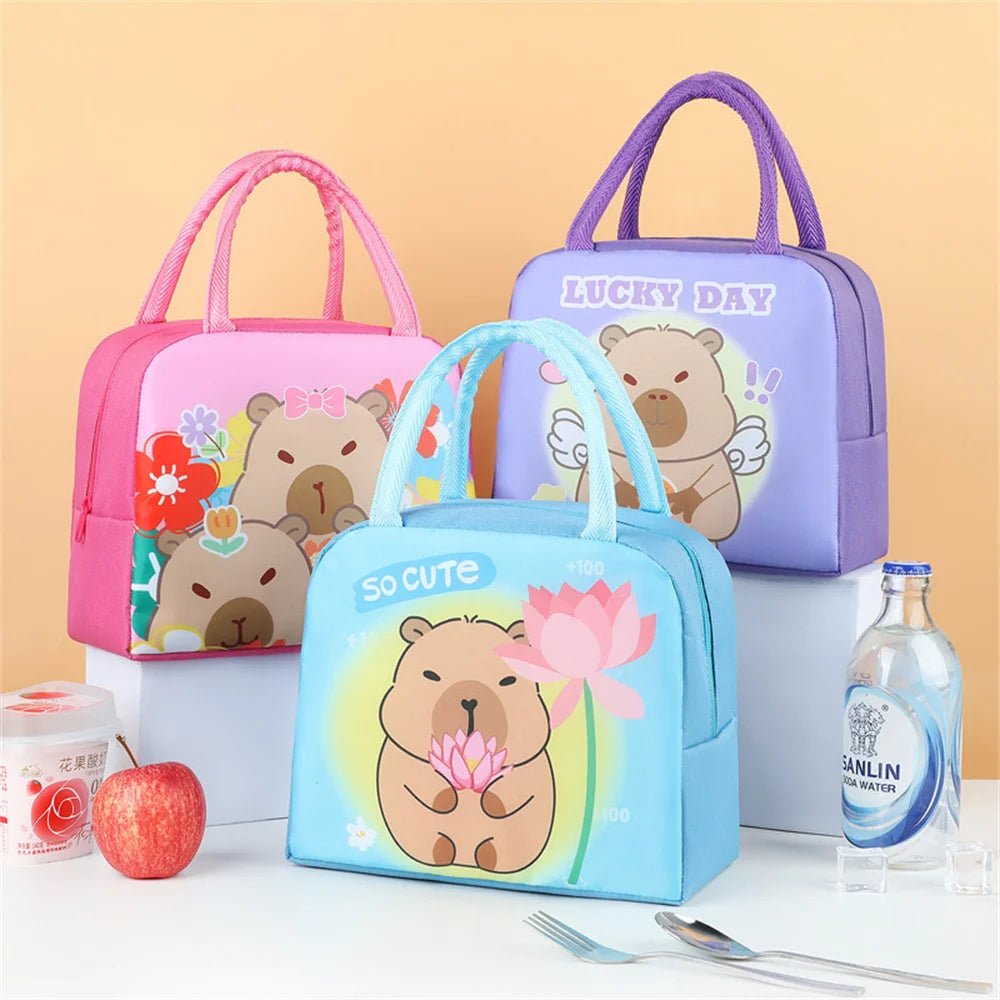 Three cartoon bear-themed kawaii lunch bags with a bottle of Sanlin water and an apple on a white surface.