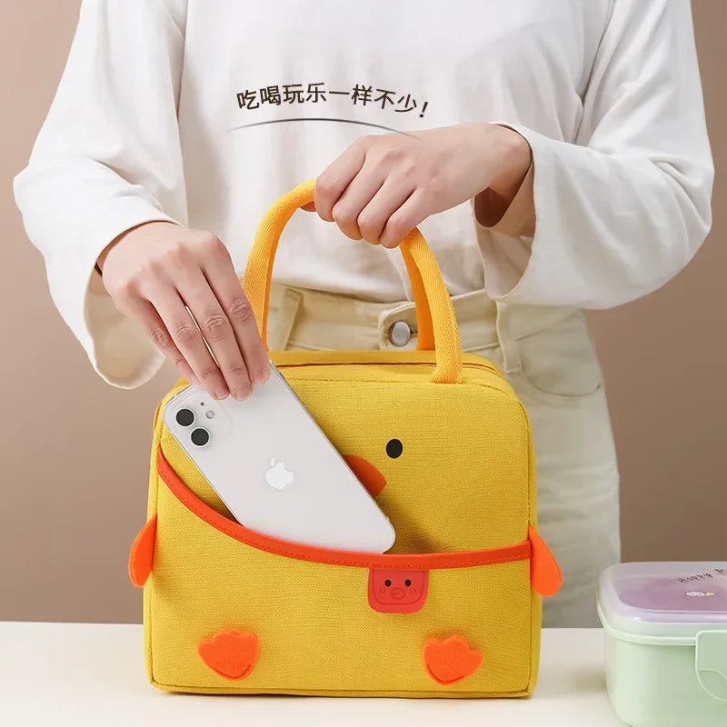 Yellow kawaii lunch bag with cartoon design held by a person, containing a white phone.