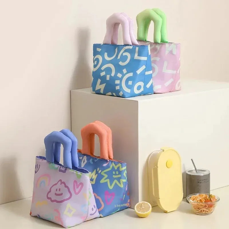 Colorful patterned kawaii bags with handle stands on a light surface.