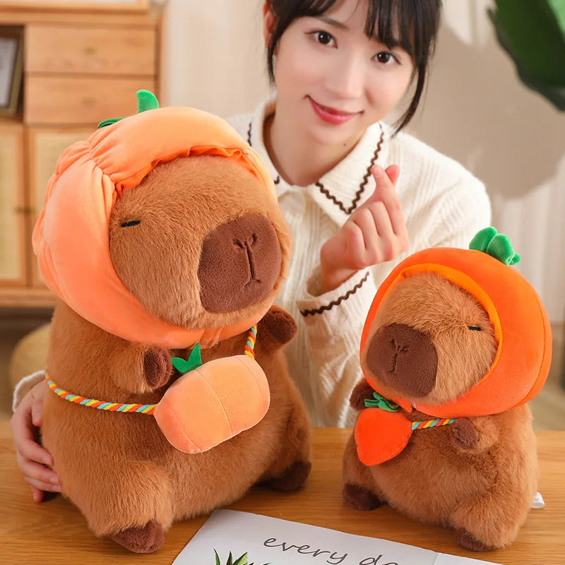 Two kawaii plush toys resembling bears with pumpkin hats on a table, with a person in the background.