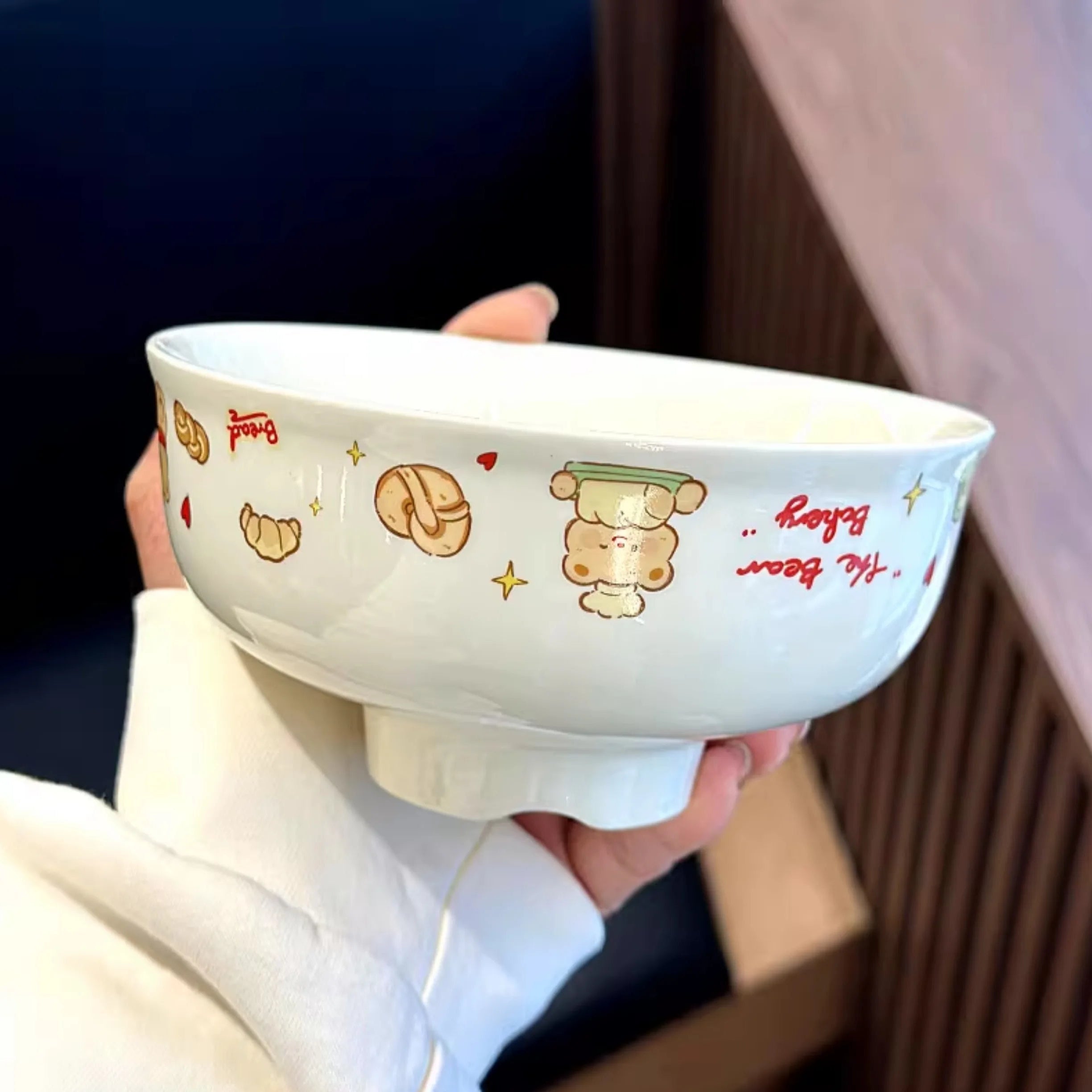 White ceramic kawaii ramen bowl with cartoon designs held by a person