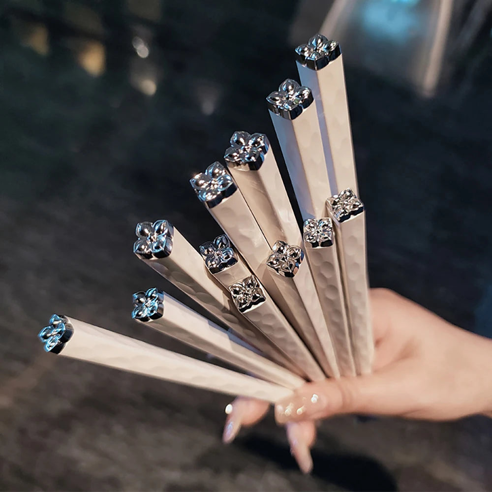 Hand holding a set of kawaii chopsticks with gemstone-like ends.
