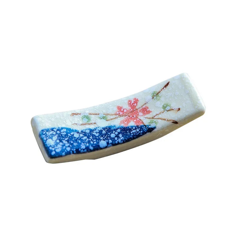 Decorative ceramic kawaii chopstick holder with floral design on a white background