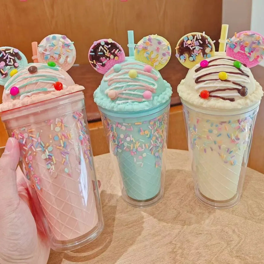Three colorful kawaii cups with decorative toppings on a wooden surface.