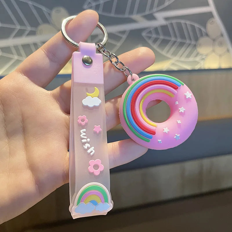 Keychain with kawaii rainbow design and 'wish' text held in a hand against a blurred background
