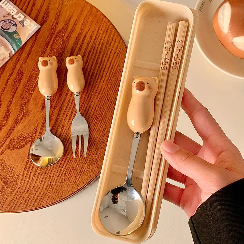 Set of bear-shaped kawaii utensils with a wooden holder on a table.
