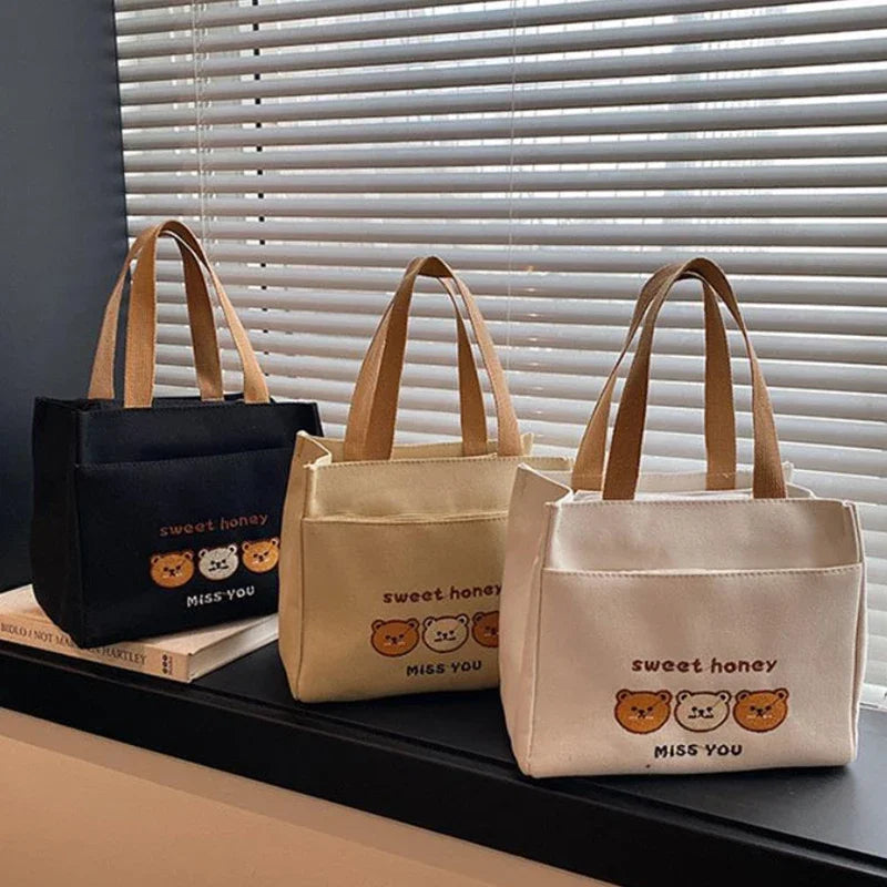 Three kawaii tote bags with 'sweet honey' and 'Miss You' text on a surface with blinds in the background.