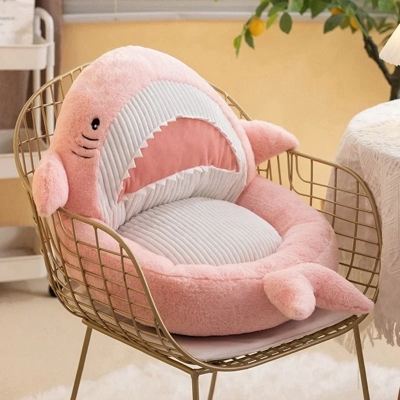 Pink shark-shaped kawaii cushion on a gold wire chair in a cozy room.