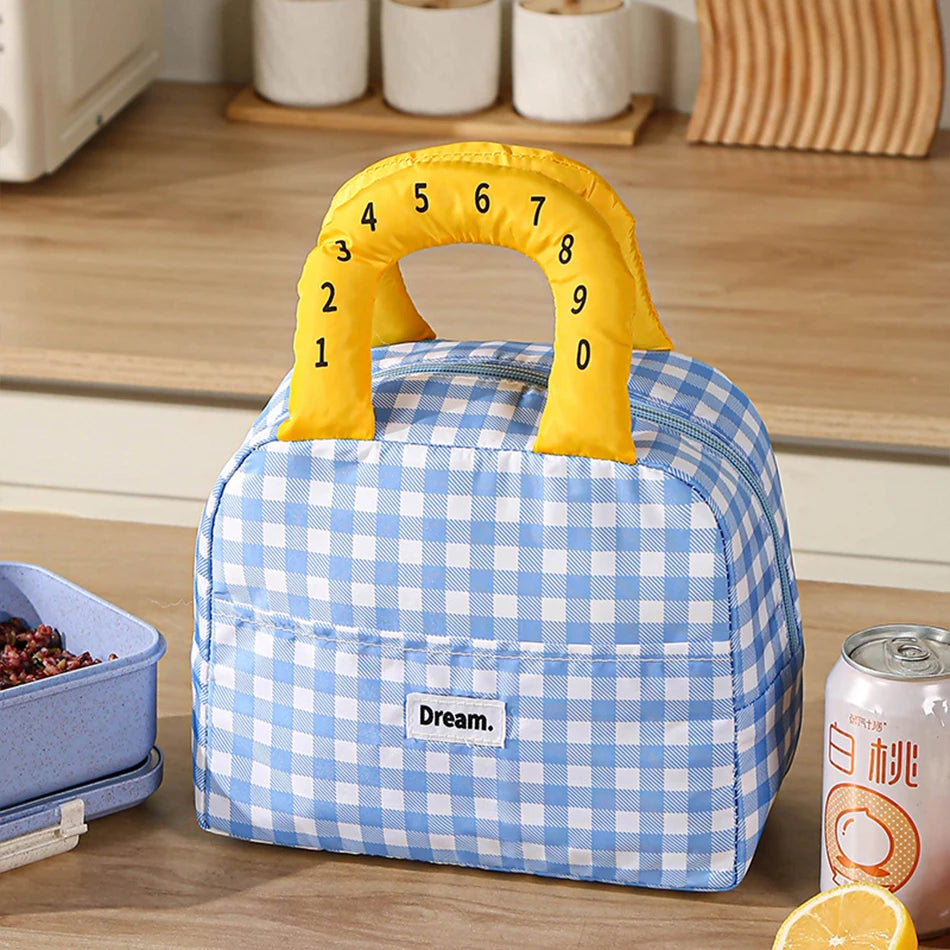 Blue checkered lunch kawaii bag with yellow handle on a wooden surface