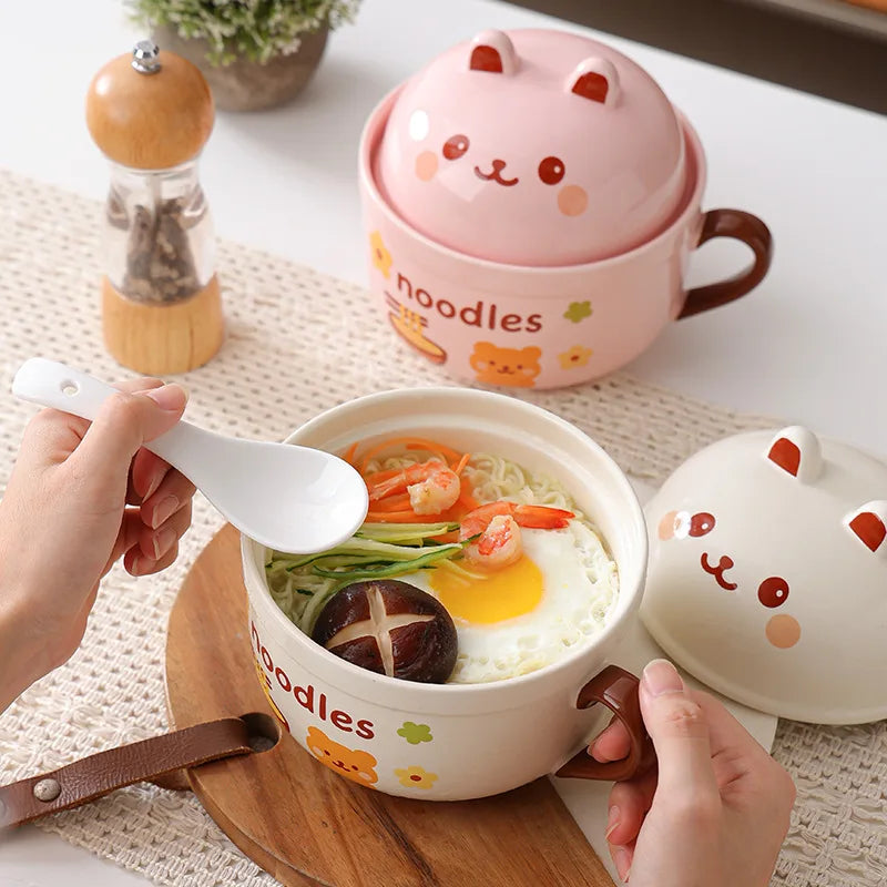 Cute cat-themed noodle kawaii ramen bowl with a lid, spoon, and hands holding the bowl.
