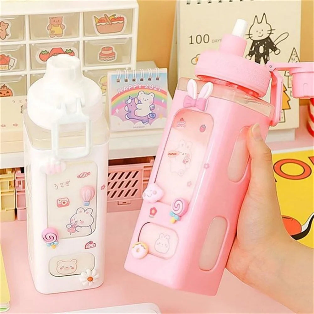 Two cute kawaii water bottles, one white and one pink, held by a hand with a colorful background.