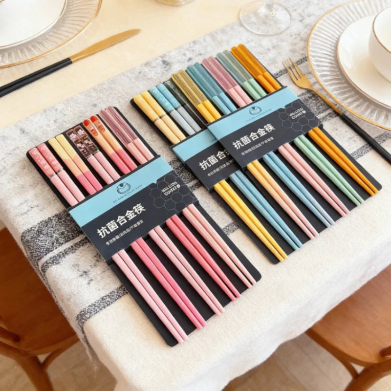 Set of colorful kawaii chopsticks with packaging on a tablecloth.