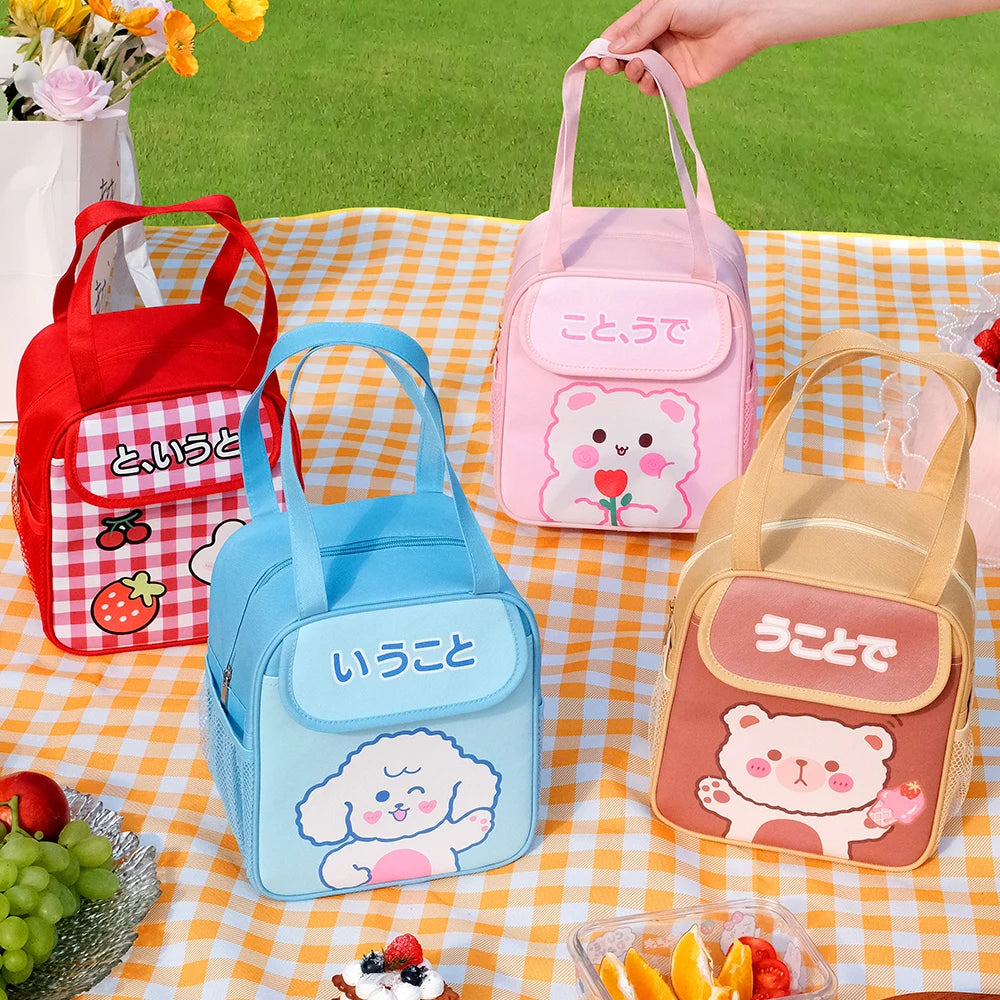 Four colorful kawaii lunch bags with cartoon designs on a checkered tablecloth.