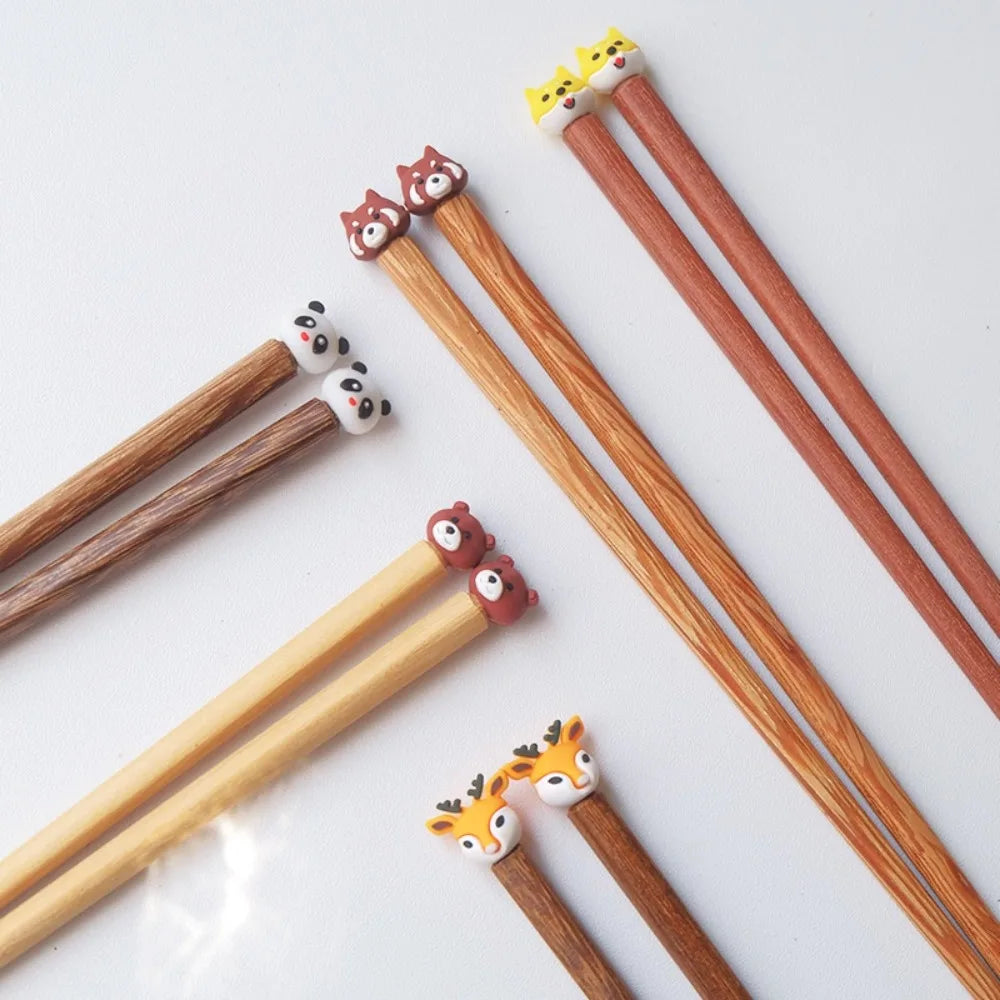 Wooden kawaii chopsticks with animal-shaped ends on a white background