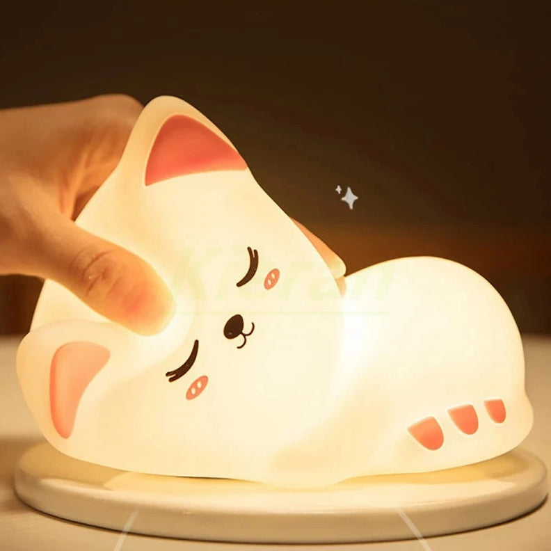 Cute kawaii cat-shaped night light being held by a hand with a dark background