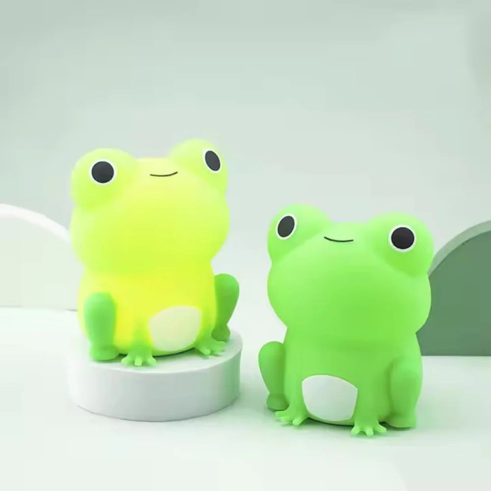 Two green frog kawaii figurines on a white background