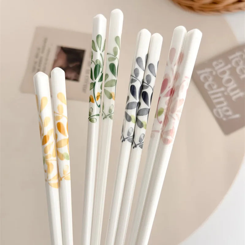 Set of decorative kawaii chopsticks with floral patterns on a neutral background