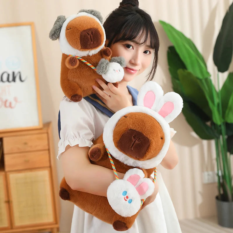 Person holding two kawaii plush toys resembling a dog and a bear in a room with a plant and wooden cabinet.
