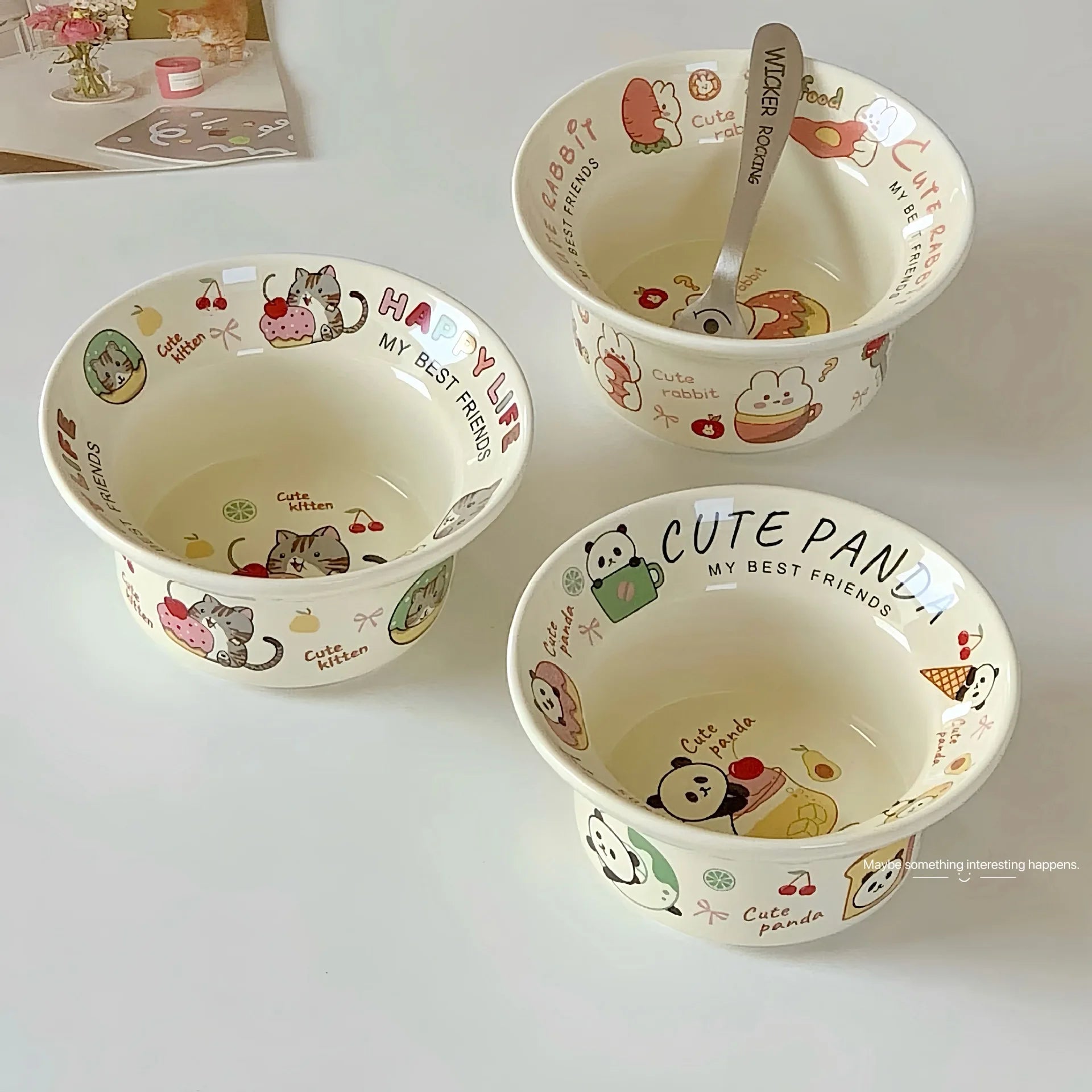 Three ceramic kawaii ramen bowls with cartoon designs on a white surface
