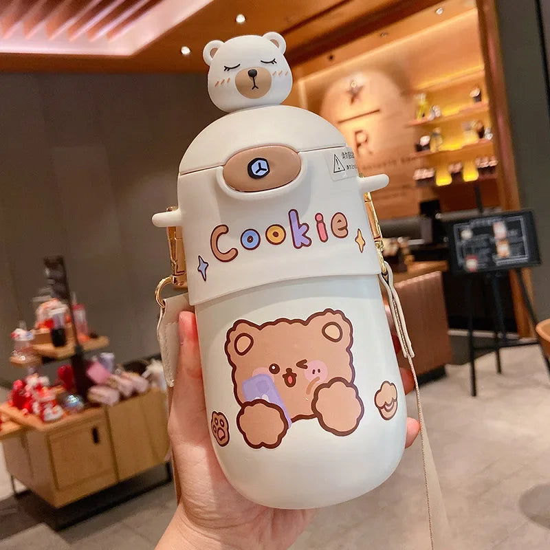 Cute cartoon-style kawaii water bottle with bear design held in a hand, indoor setting.