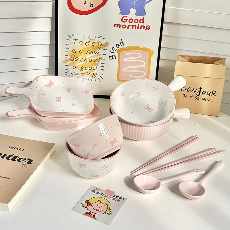 A set of ceramic kawaii ramen bowl with white and pink bows sitting on the table