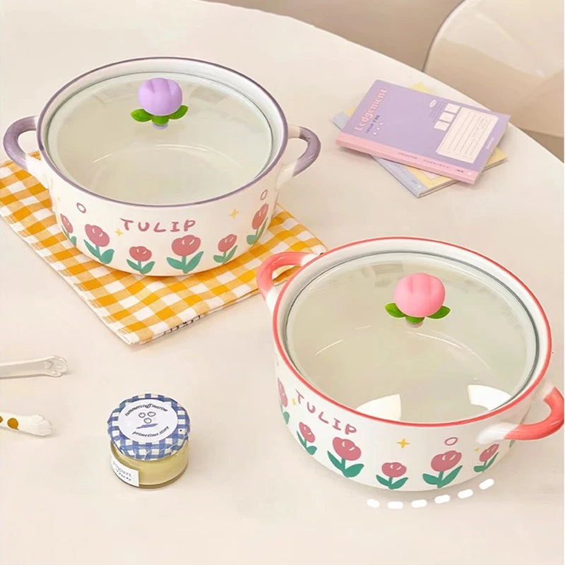 Two ceramic kawaii ramen bowls with floral designs and colorful lids on a table.