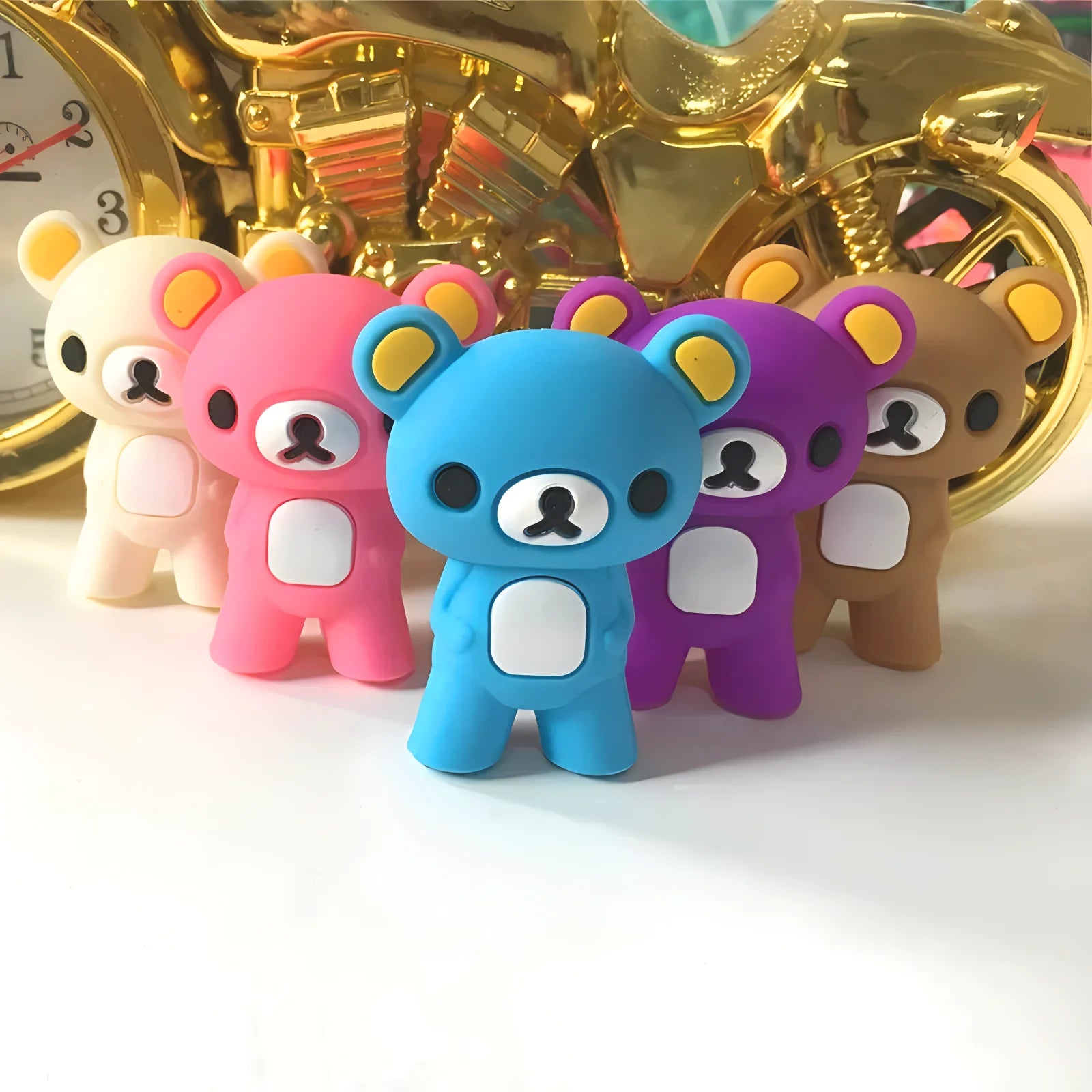 Colorful bear-shaped kawaii chopsticks in front of a gold decorative object.