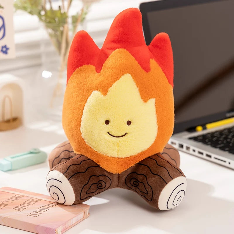 Kawaii plush toy shaped like a flame on a desk with a laptop in the background