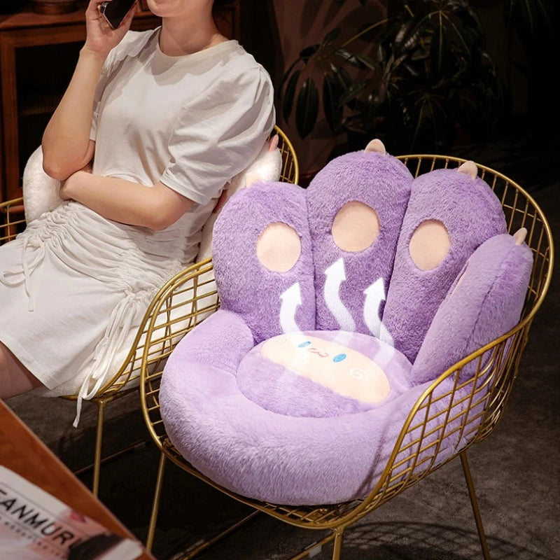 Person sitting on a gold chair with a purple paw-shaped kawaii cushion