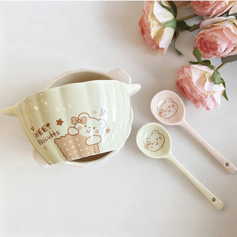 A pumpkin shaped kawaii bowl next to a pair of spoons