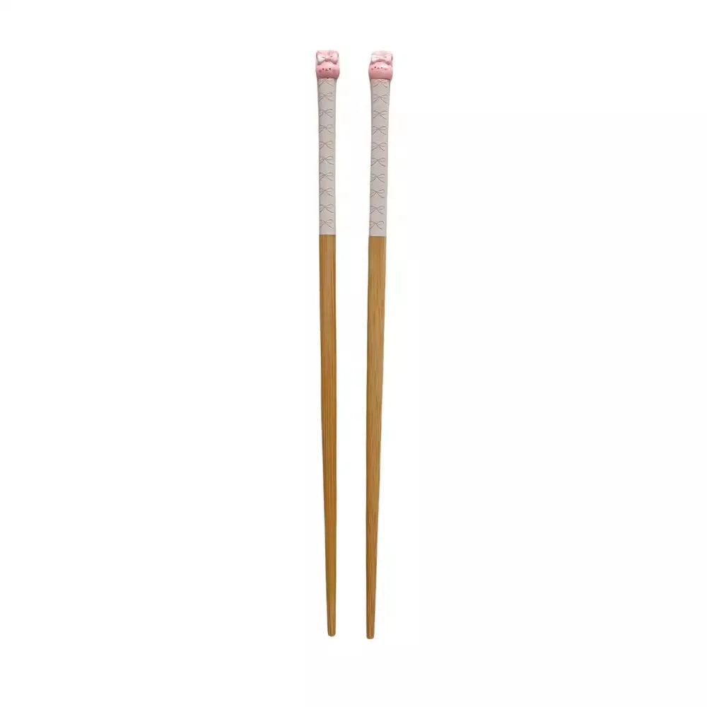 Pair of wooden kawaii chopsticks with pink ends on a white background