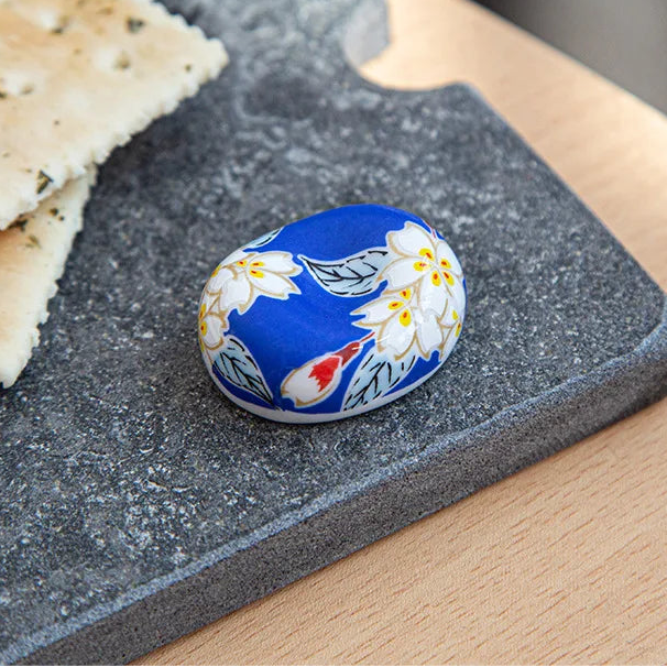 Decorative kawaii chopstick holder with floral design on a slate surface with crackers
