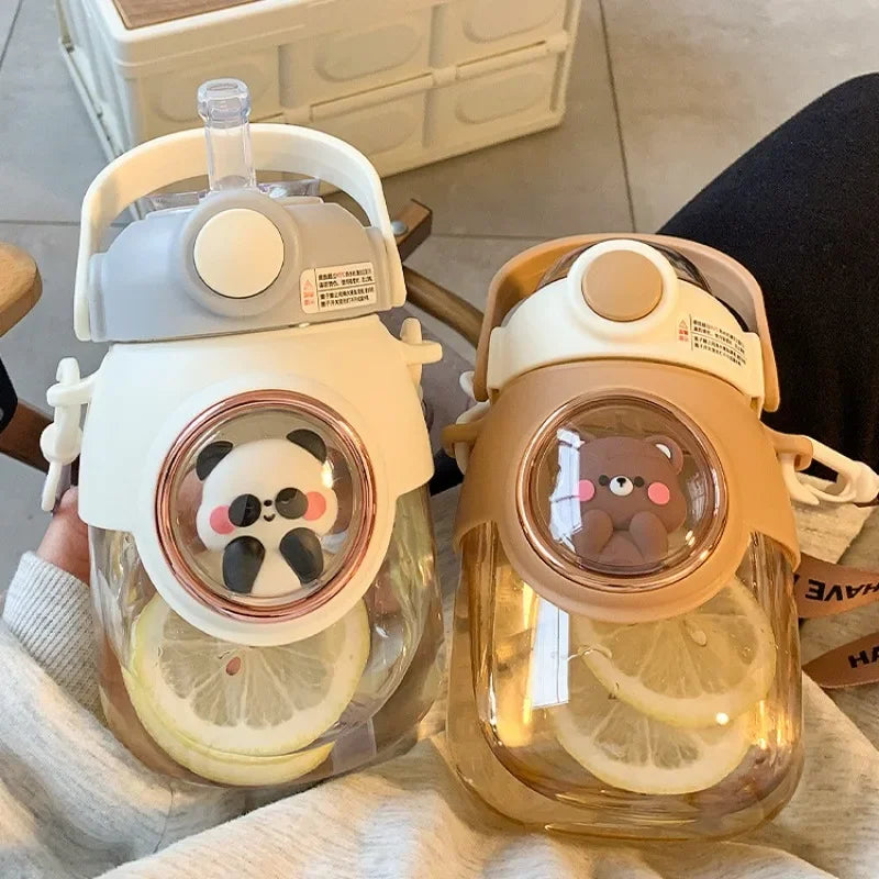 Two transparent kawaii water bottles with panda and bear designs on a light surface.