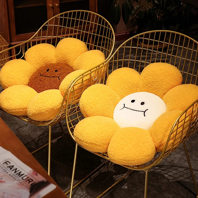 Two yellow flower-shaped kawaii cushions with smiling faces on wire chairs.