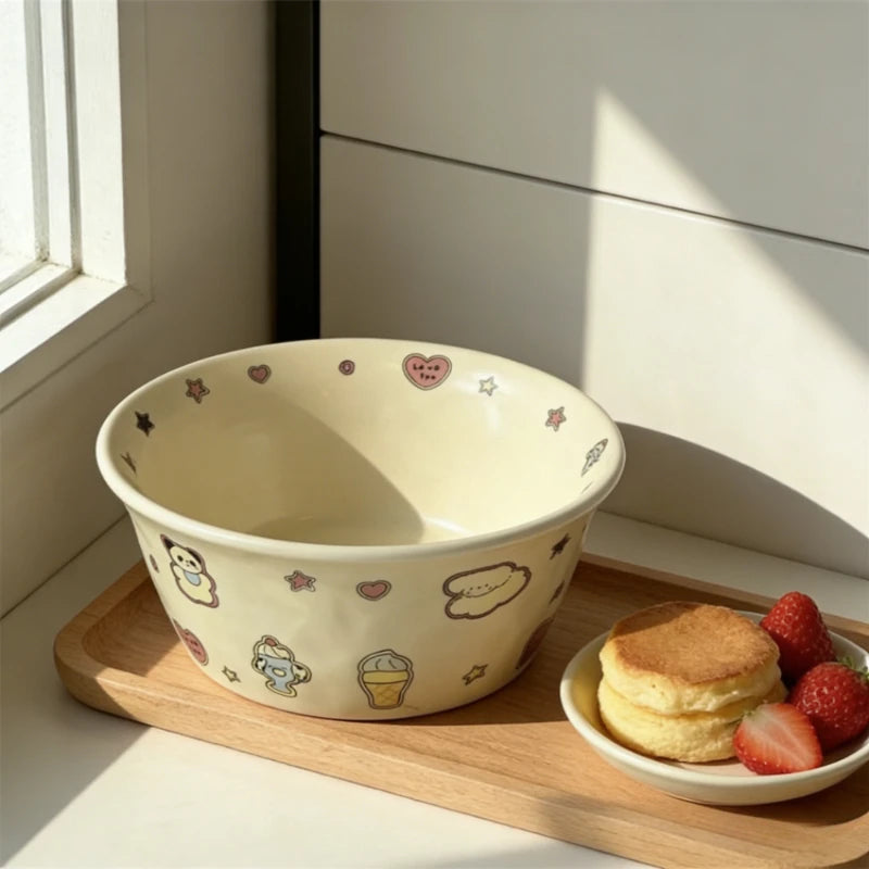 Ceramic kawaii ramen bowl with cartoon designs on a wooden tray with a side of pancakes and strawberries.