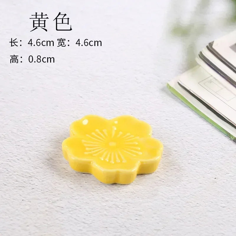 A yellow floral shaped kawaii chopstick holder sitting on a table