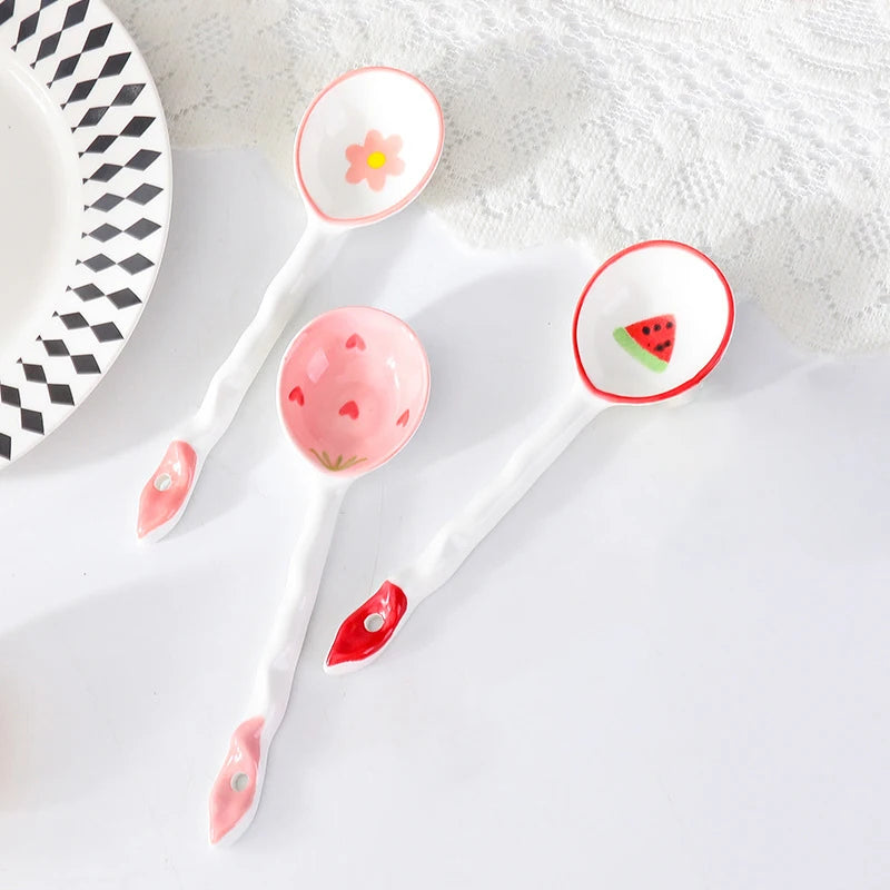 Three white kawaii spoons on a white fabric surface