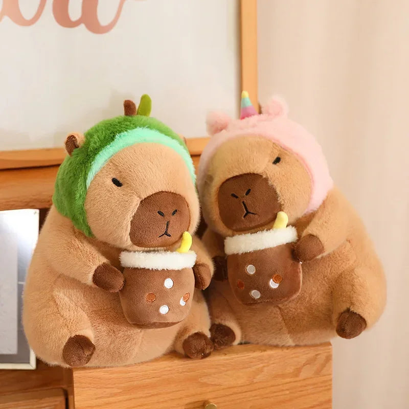 Two kawaii plush toys resembling animals in winter hats and scarves on a wooden surface.