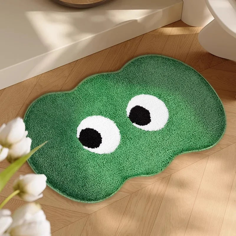 Green bath kawaii mat with eyes on a wooden floor